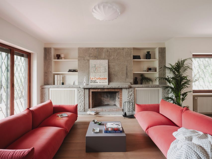 Living room with stone fireplace in revamp of 1960s villa by StudioTamat