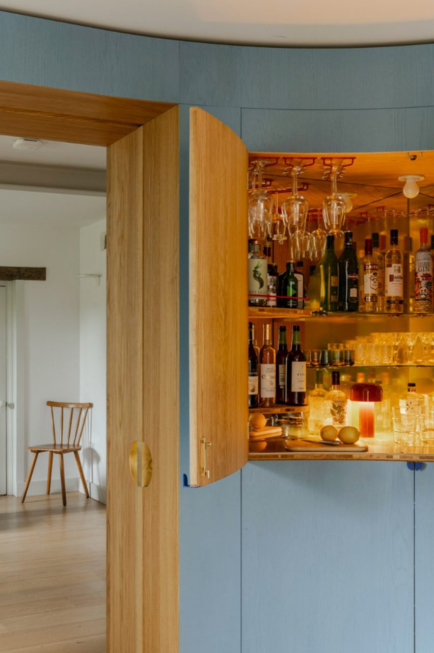 Drinks cabinet integrated into blue timber wall
