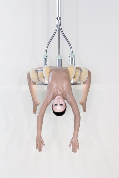 Woman hanging from a chandelier designed by Bianca Censori