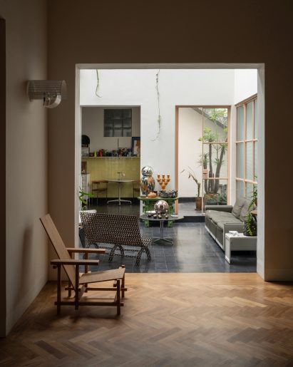 Balcony with dark floor tiles viewed from a living space with herringbone parquet