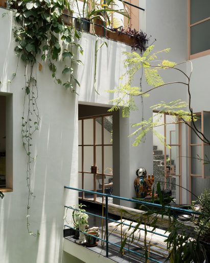 An atrium with balconies on each level and metalwork lacquered in peach and dark green
