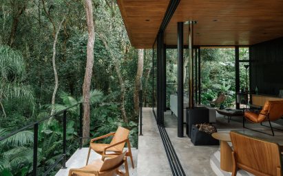 Floor-to-ceiling glass panels retracted to open a living space to the outdoors