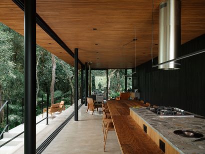 Concrete floors and a wood-lined ceiling extend through a home's open social spaces
