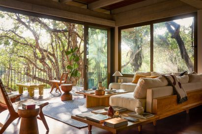 Living room with sliding glass doors overlooking treetops