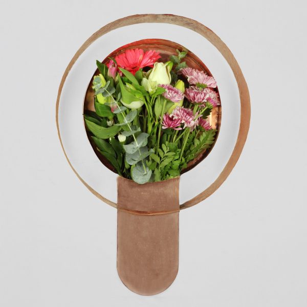 a copper vase with flowers inside