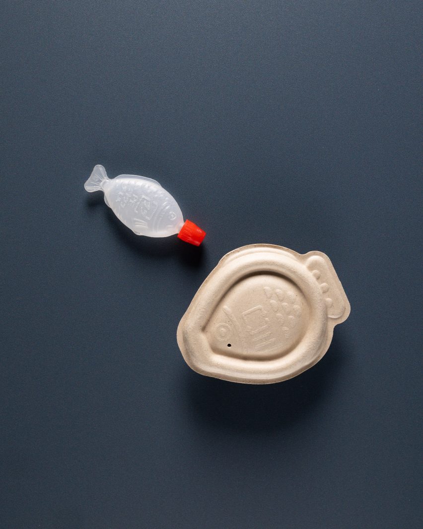 Photo of a classic plastic soy sauce fish next to the bigger bagasse pulp compostable packaging by Heliograf and Vert Design