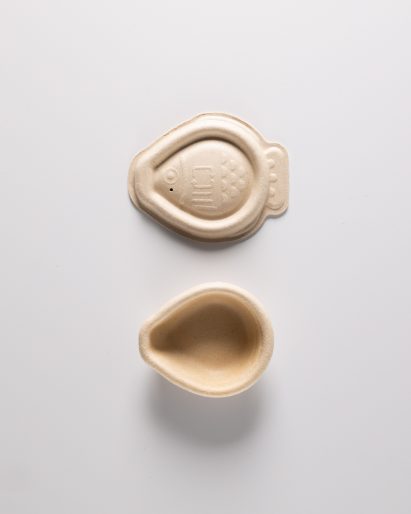 Photo of the top and bottom of the compostable soy-sauce plant pulp packaging seperated