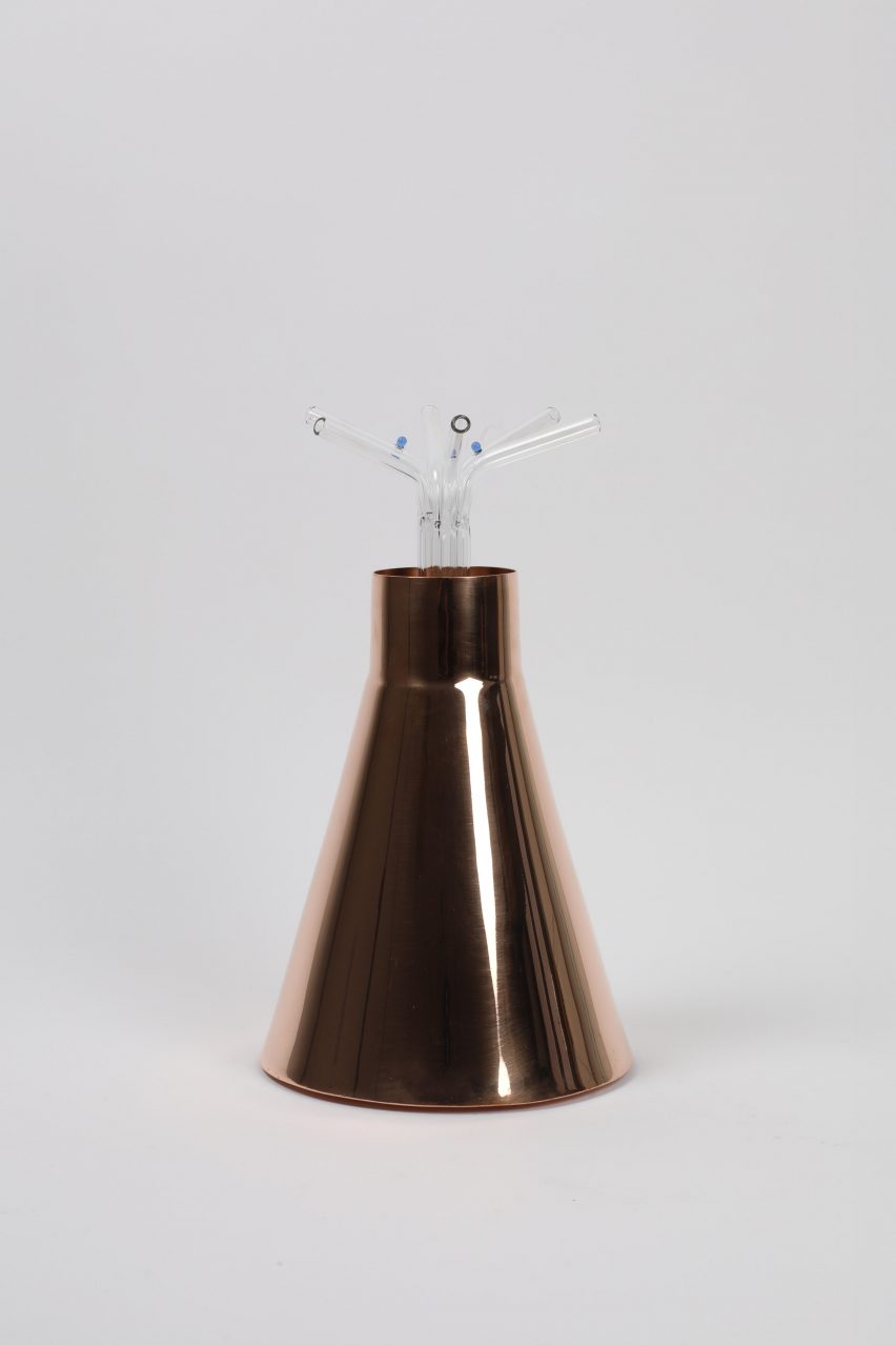 a copper vase with straws at the top