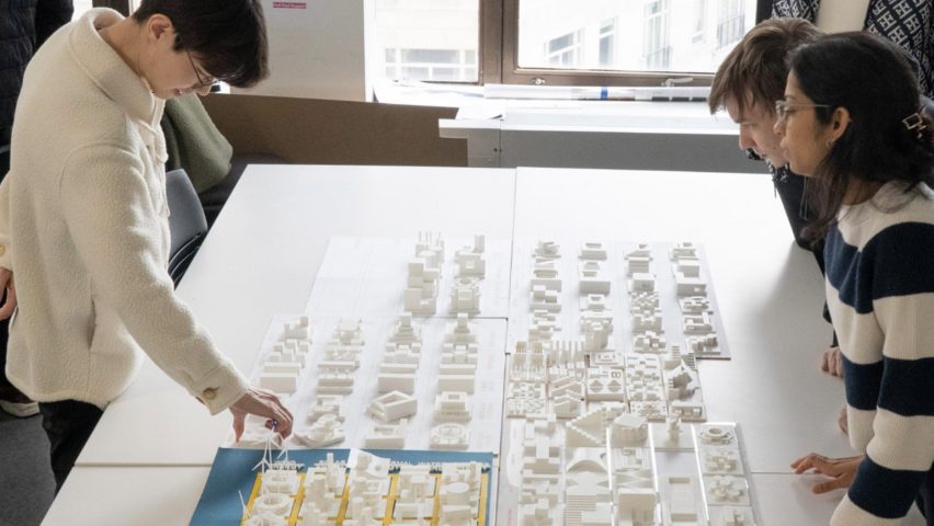 a photograph of students handling an architecture model