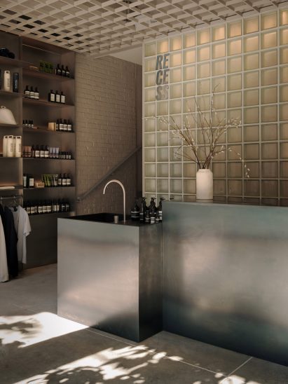 The light-filled reception of Recess bathhouse, which includes a raw steel counter and sink