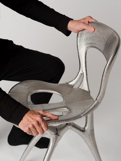 Close-up photo of the Ross Lovegrove x Google DeepMind x Modem chair showing flowing organic lines in metal forming the seat