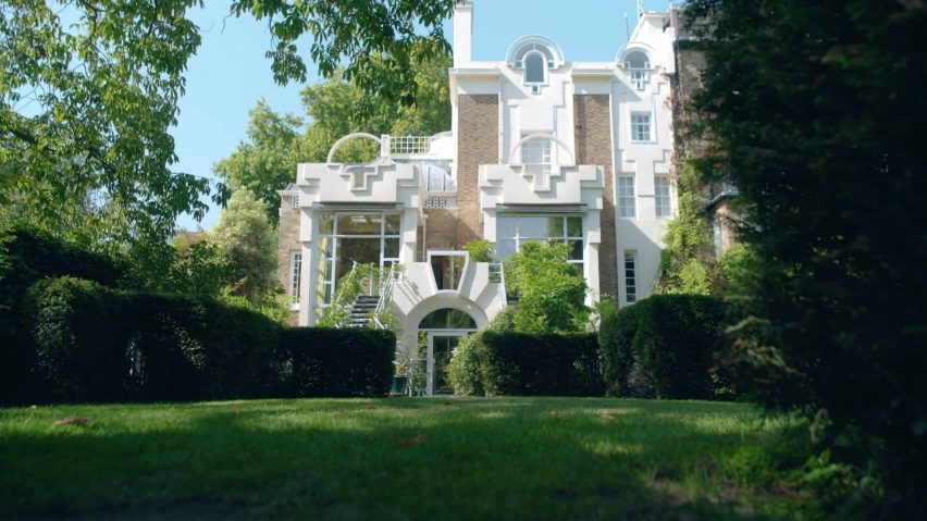 Front view of The Cosmic House in west London, framed by trees and manicured gardens