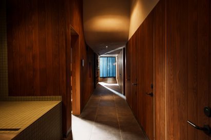 Wood lines a corridor where lockers, showers and changing rooms can be found
