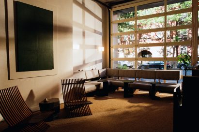 Lounge featuring cushioned bench seating below a garage-style window
