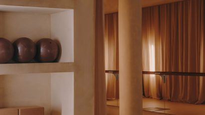 Barre studio with floor-to-ceiling curtains and mirrored walls
