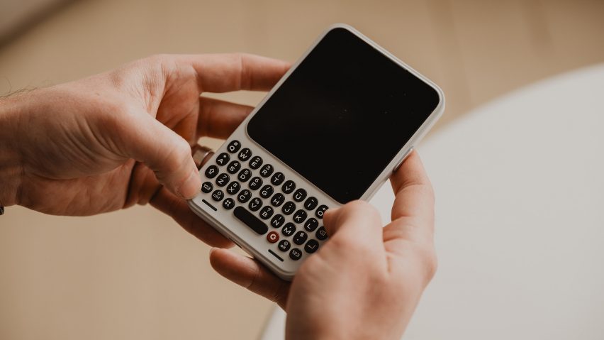 Photo of a person's hands holding the Clicks Communicator phone as if to type on the QWERTY keyboard