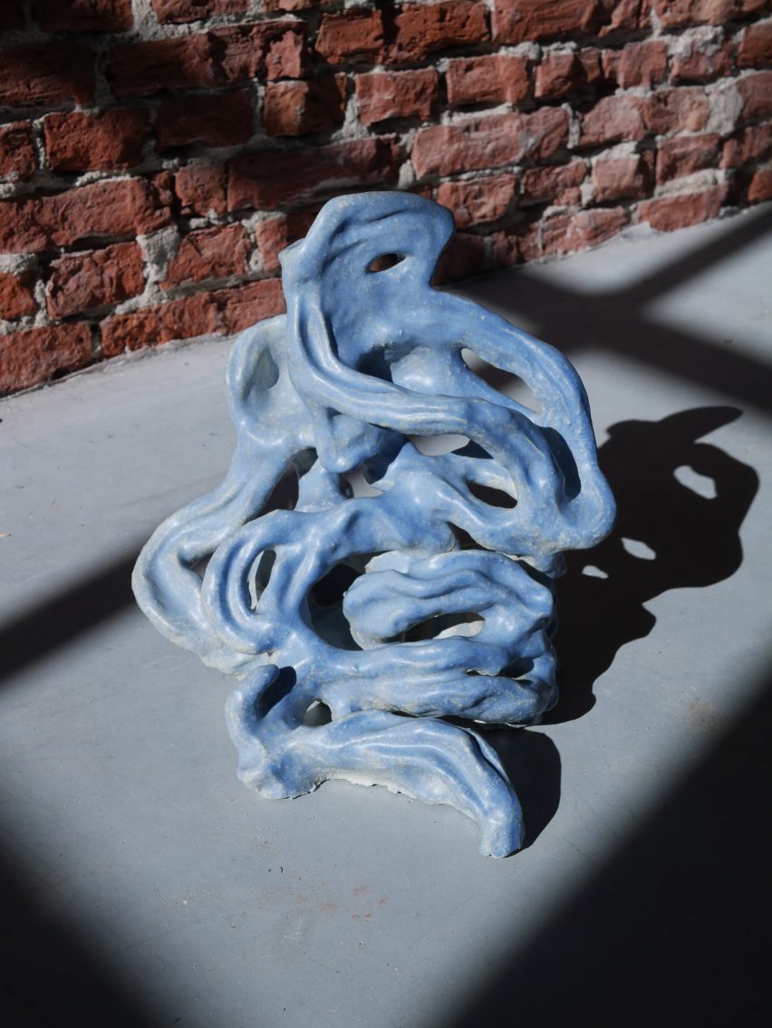 Photo of a ceramic object with loops of clay coiled around and around themselves like a small intestine, but with light blue glaze