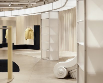 White shopping space with floor sculpture and yellow rail