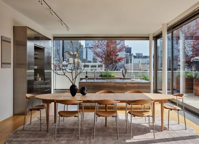 Dining room with a large wooden table and views of Manhattan on two sides