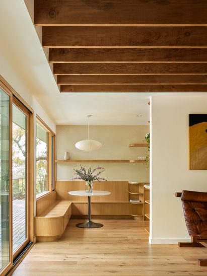 White oak millwork forms a dining nook under a large window