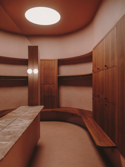 Changing room with rounded skylight and wooden lockers