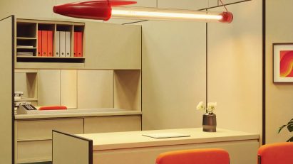 Pen-shaped lamp suspended from the ceiling in a retro-style office