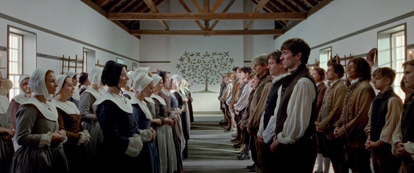 Still from The Testament of Ann Lee showing Shakers assembled in rows within their meeting and dance hall, the Tree of Life painting adorning a far wall