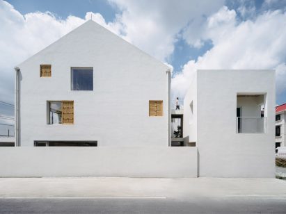 White guesthouse exterior with bamboo panels