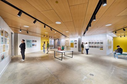 Large exhibition space featuring concrete floor and wood-lined ceiling