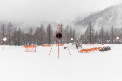 Orange football pitch in snowy landscape