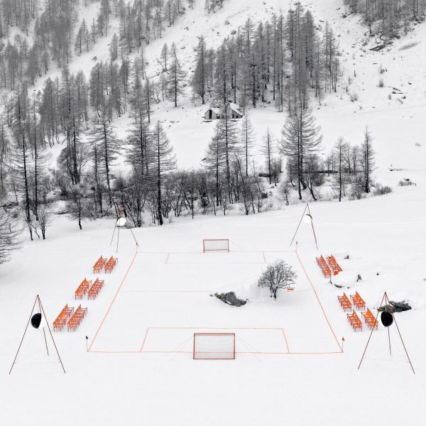 Orange football pitch in snowy landscape