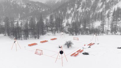 Orange football pitch in snowy landscape