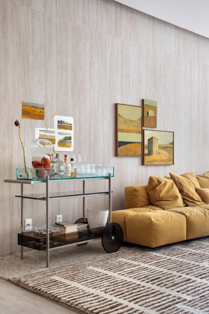 A triptych of paintings by Anthony Mazza above a tone-matched sofa