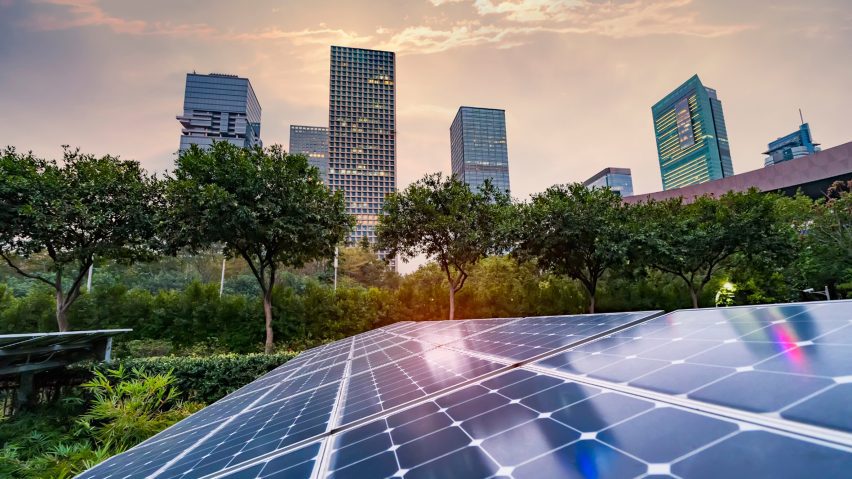 a solar panel on top of a building, with a city skyline in the distance