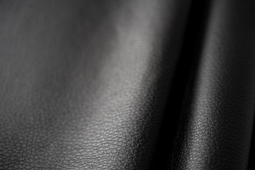 Close-up photo of Arda's New Grain material showing a soft, supple black leather-like material with a fine grain pattern on the surface