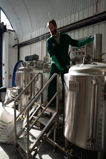 Photo of Arda Biomaterials' production facility, with several metal tanks like at a microbrewery and a person tending to them