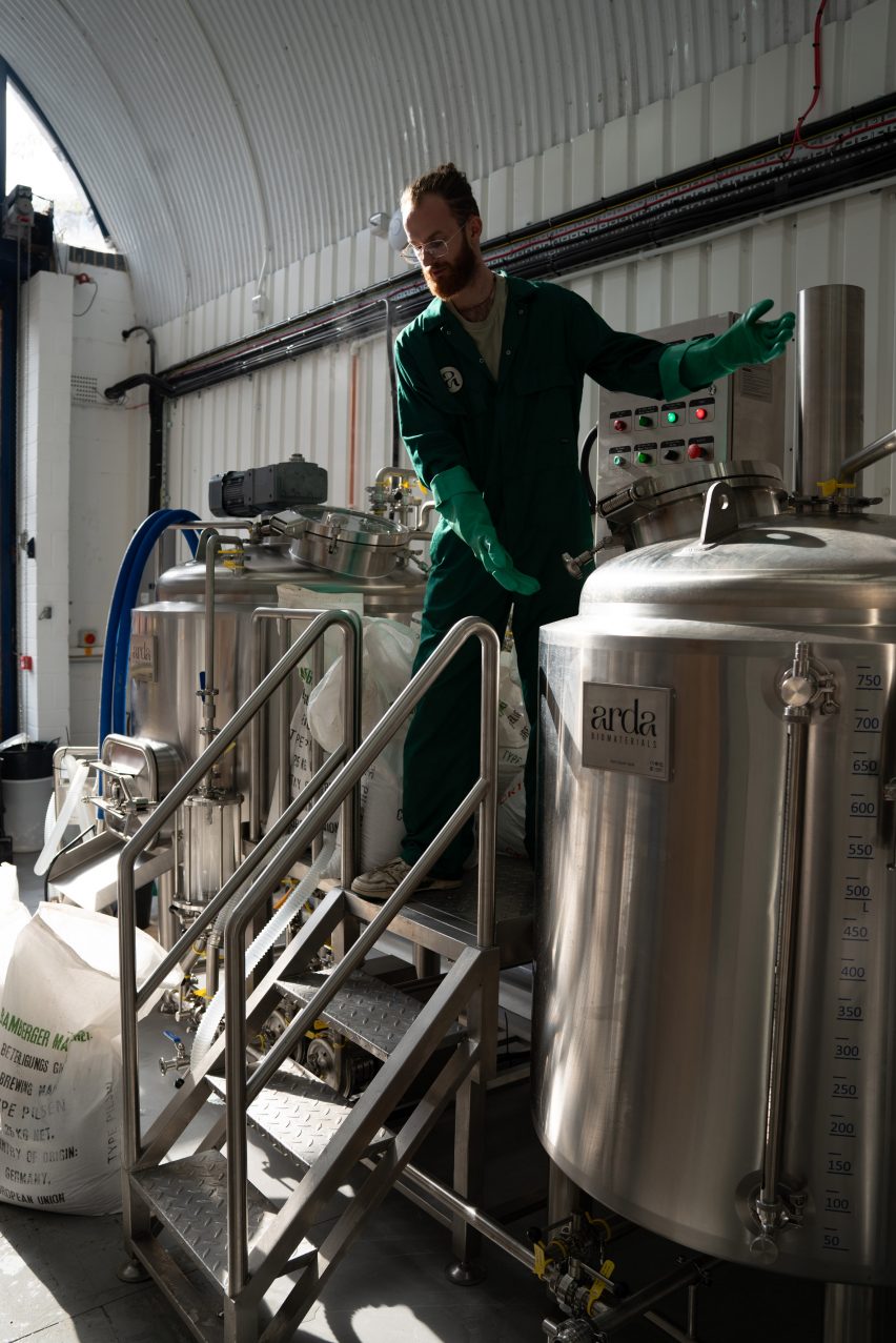 Photo of Arda Biomaterials' production facility, with several metal tanks like at a microbrewery and a person tending to them