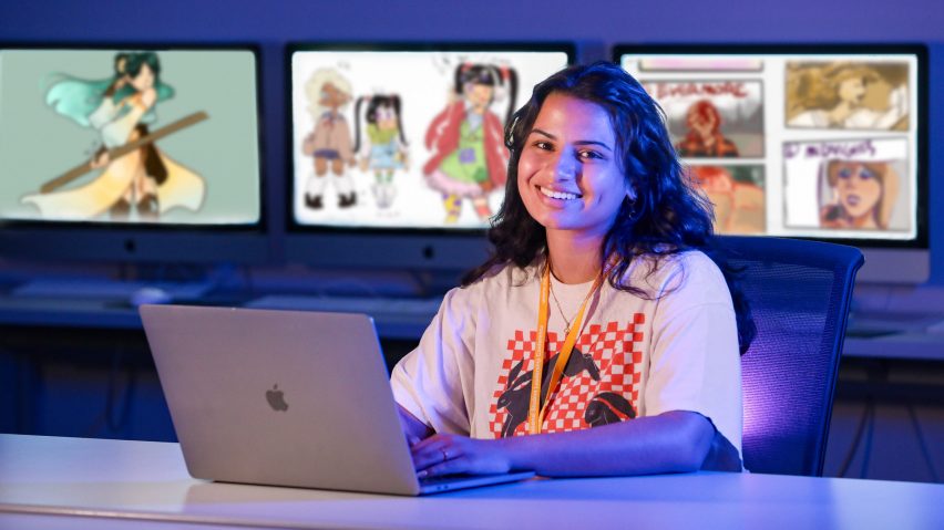 person sitting in front of drawings on computer screens