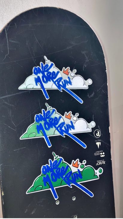 Photo of three Snow Seeds sticker prototypes on a snowboard