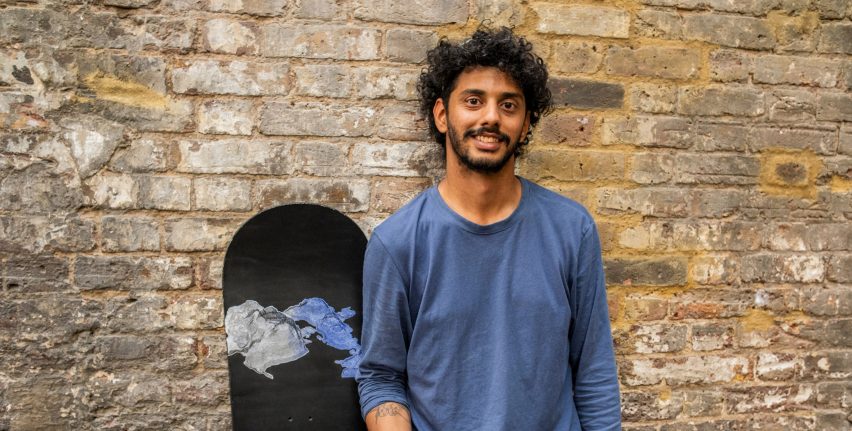 Photo of Tanay Wadodkar standing beside a snowboard bearing one of his Snow Seeds stickers