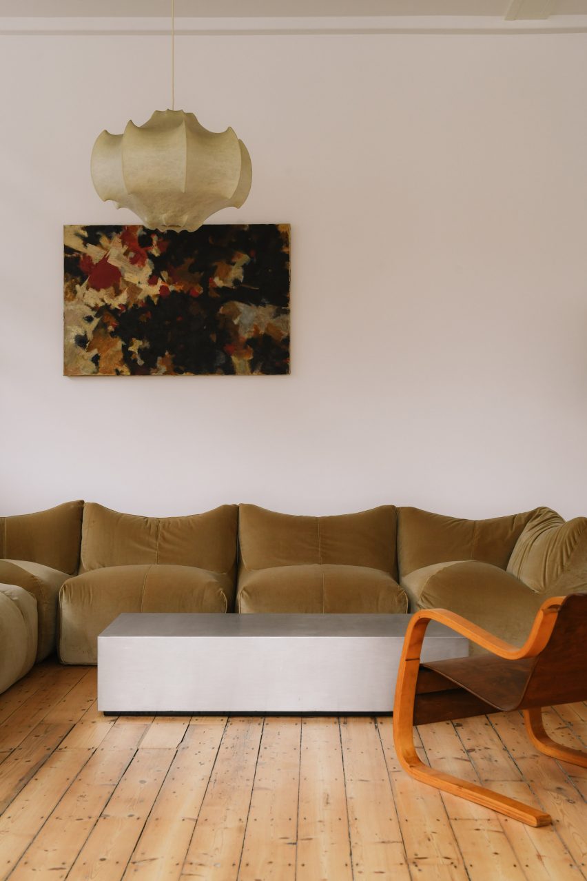 Sculptural lamp above velvet sofa
