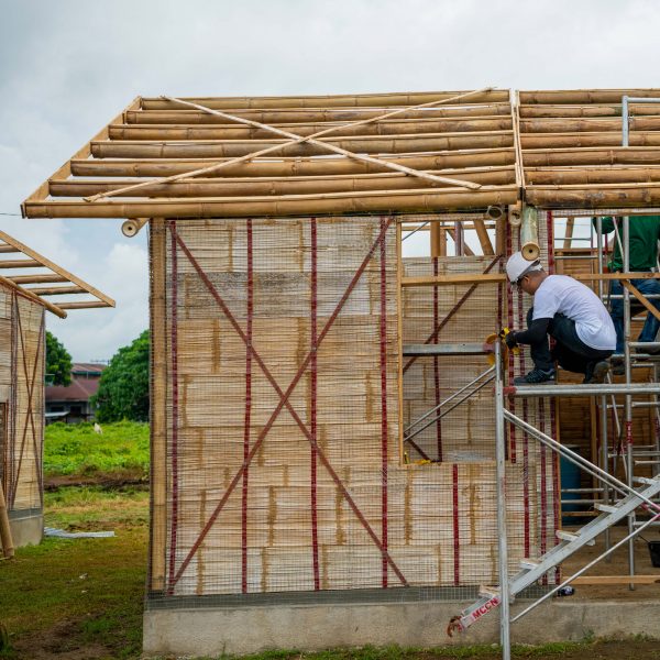 People building a house from bamboo