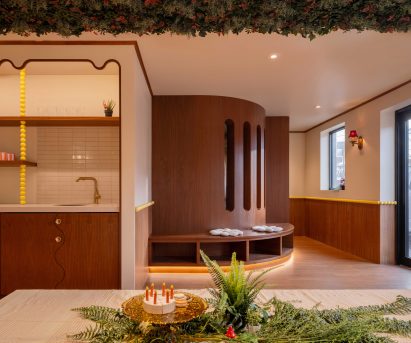 An events space with walnut walls, yellow bead details and a floral ceiling installation