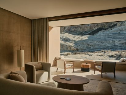 A guest suite with a fully retractable glass wall, facing a rock formation