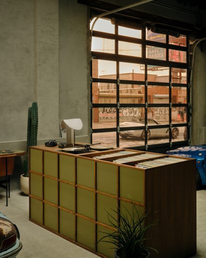 A walnut listening station and bar at the centre of a garage-style space