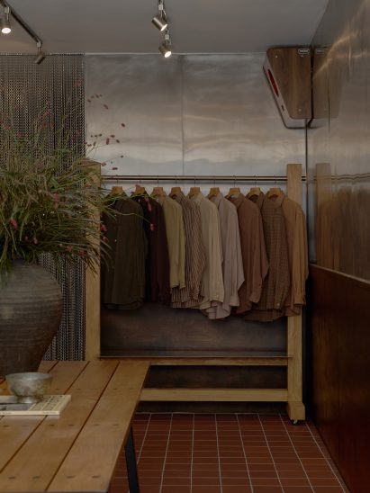 Clothing displayed on a rail against a stainless steel wall