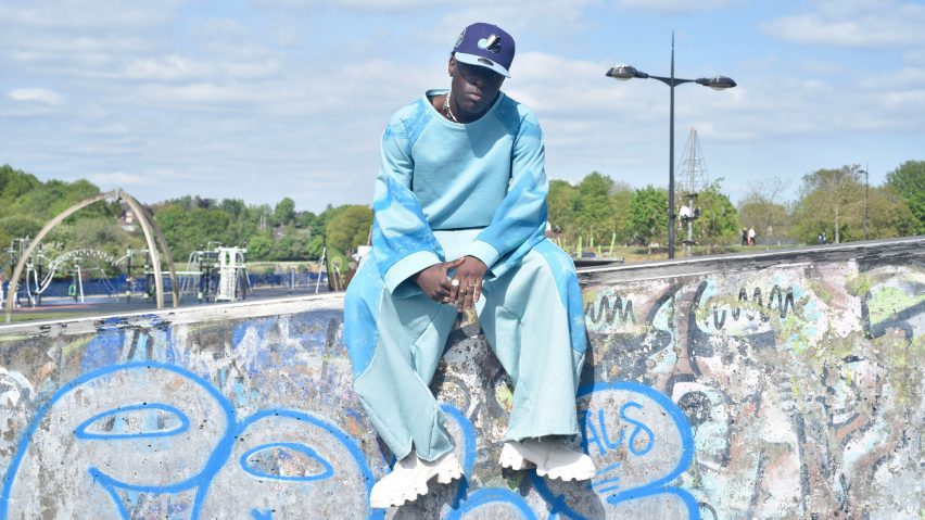 a photograph of a person in blue garments sat on a wall