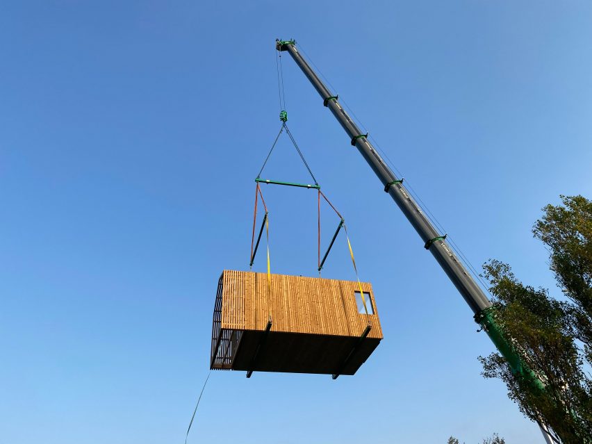 Crane carrying modular unit to site