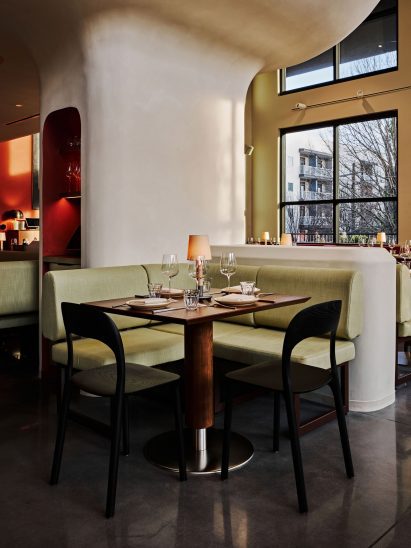 Pistachio-hued banquette in front of a curved plaster column