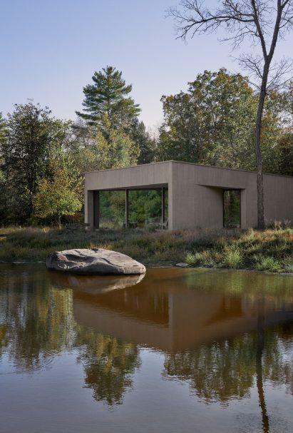 Stucco guesthouse reflected in a pond